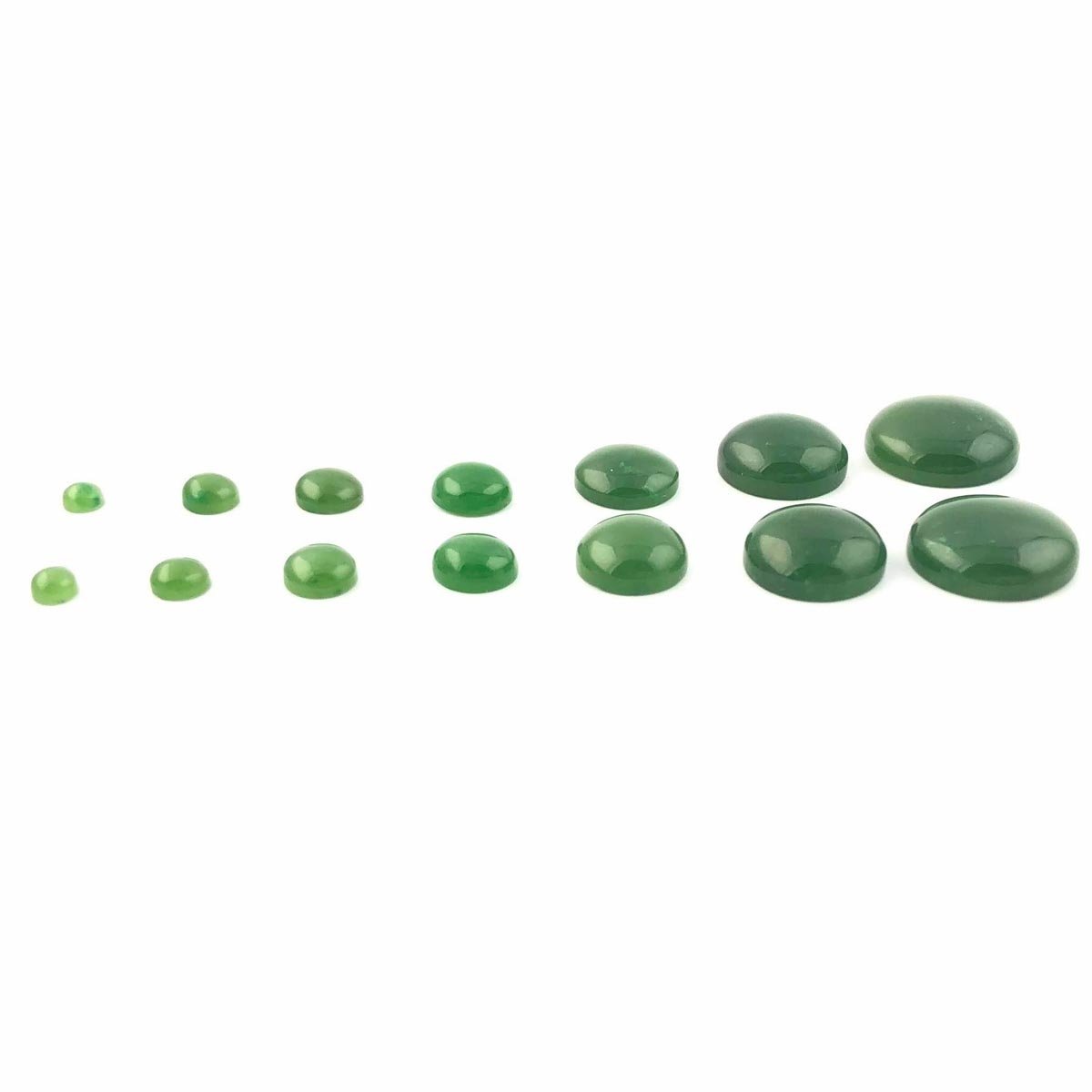 Row of green round cabochons in increasing sizes on a white background