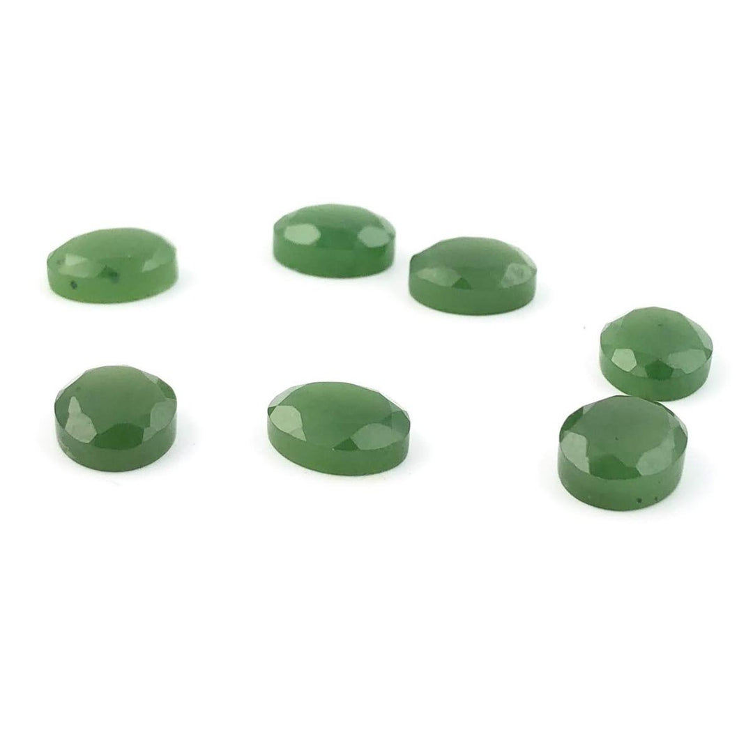 Seven green A Grade 8x10mm faceted cabochons on white background