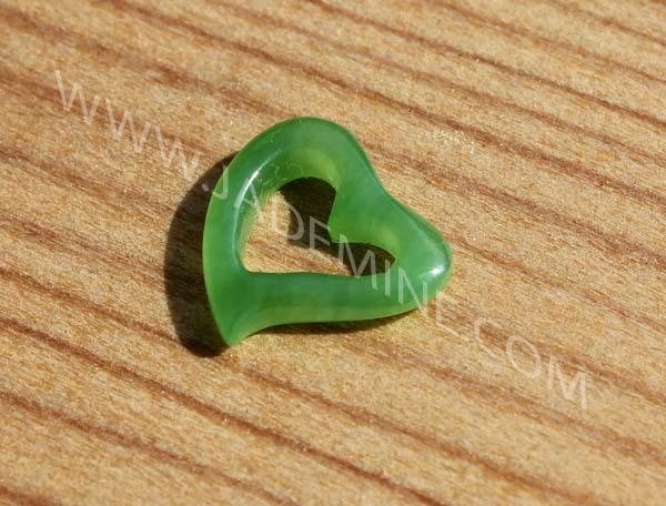 Green jade Charm, Heart on a wooden background, and www.jademine.com watermarked ontop 