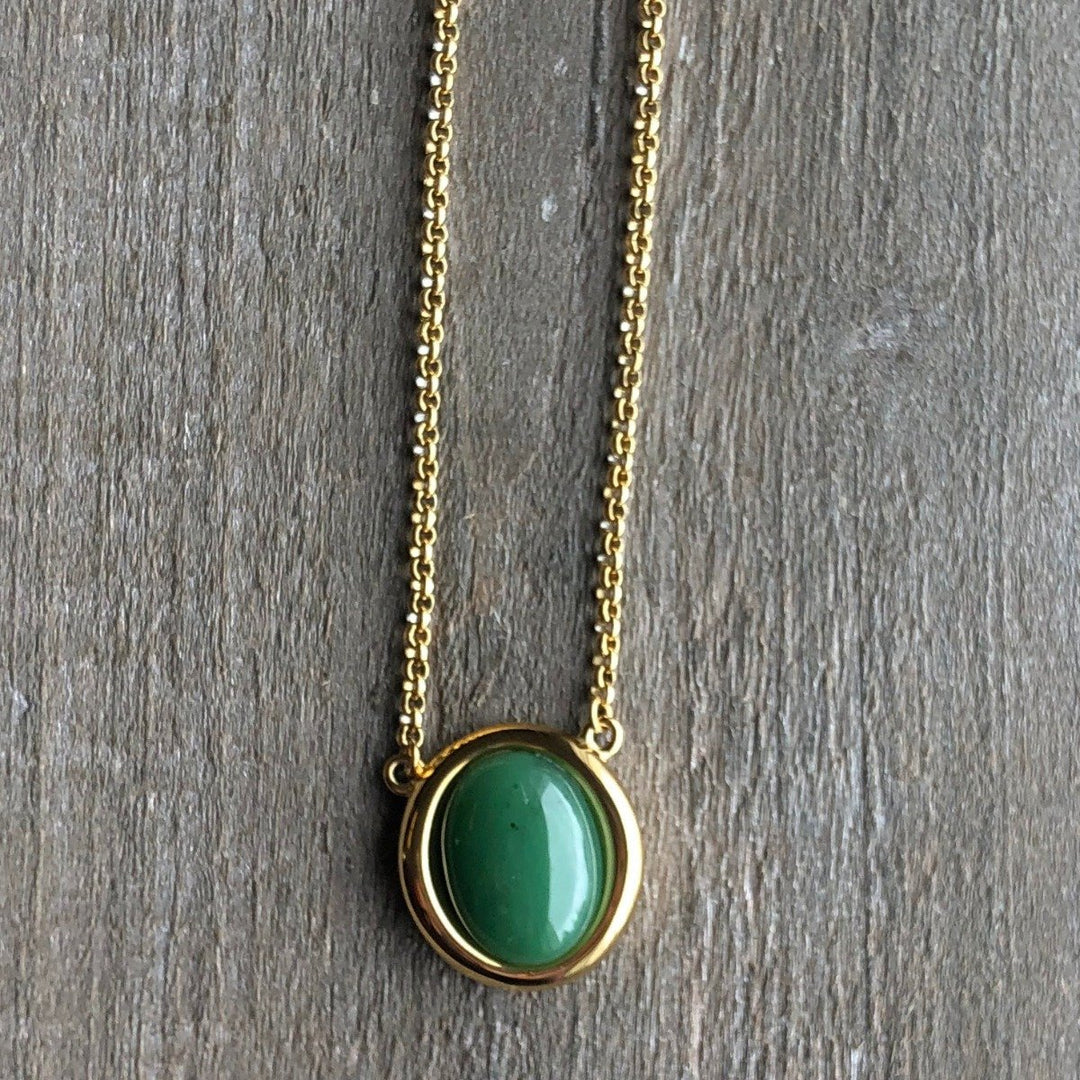 Gold-tone chain necklace featuring a round green jade pendant in a gold bezel