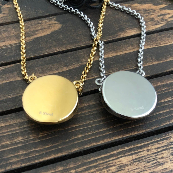 Two round stainless steel pendants in gold and silver tones on matching chains