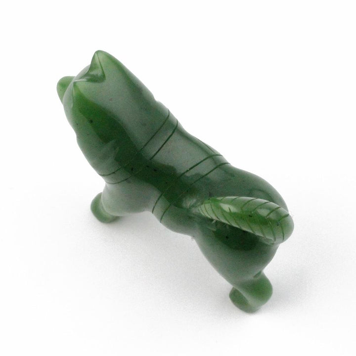 Top-angle view of green stone husky figurine with carved lines along its body.