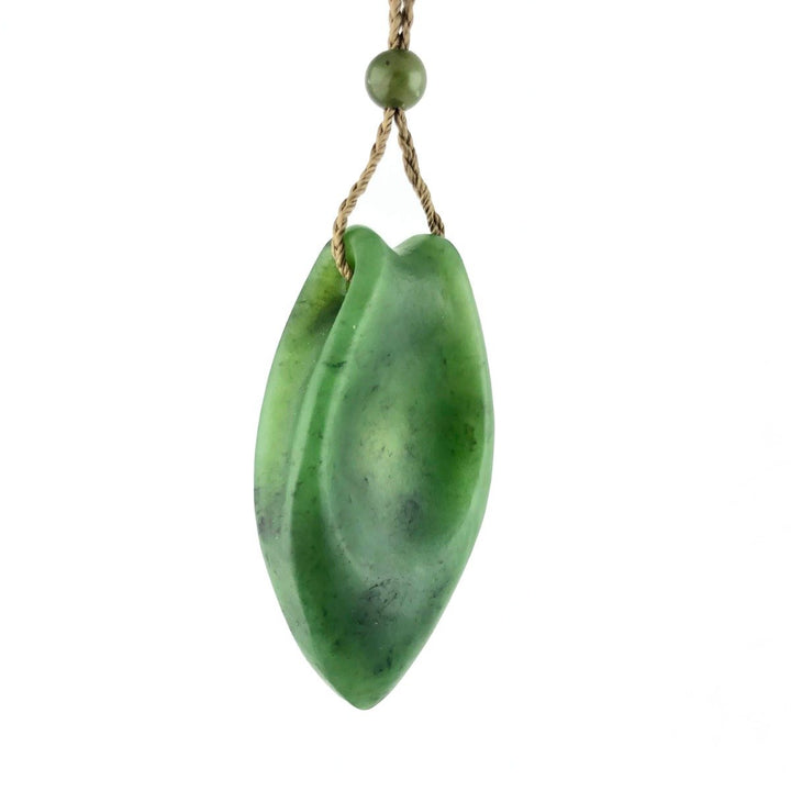 Green jade pendant with a two leaf shape on a natural twisted cord with a small bead above.