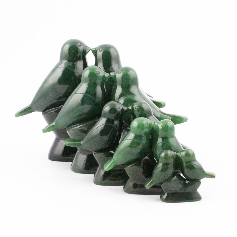 Cluster of glossy green glass lovebird figurines arranged together