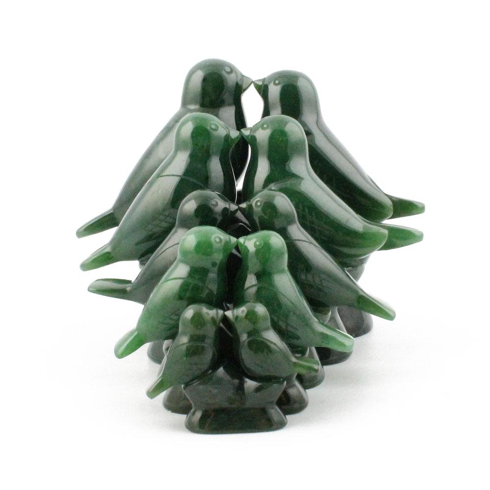 Group of glossy green lovebird figures clustered into a compact multi bird sculpture