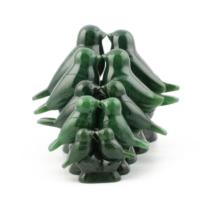 Group of glossy green lovebird figures clustered into a compact multi bird sculpture