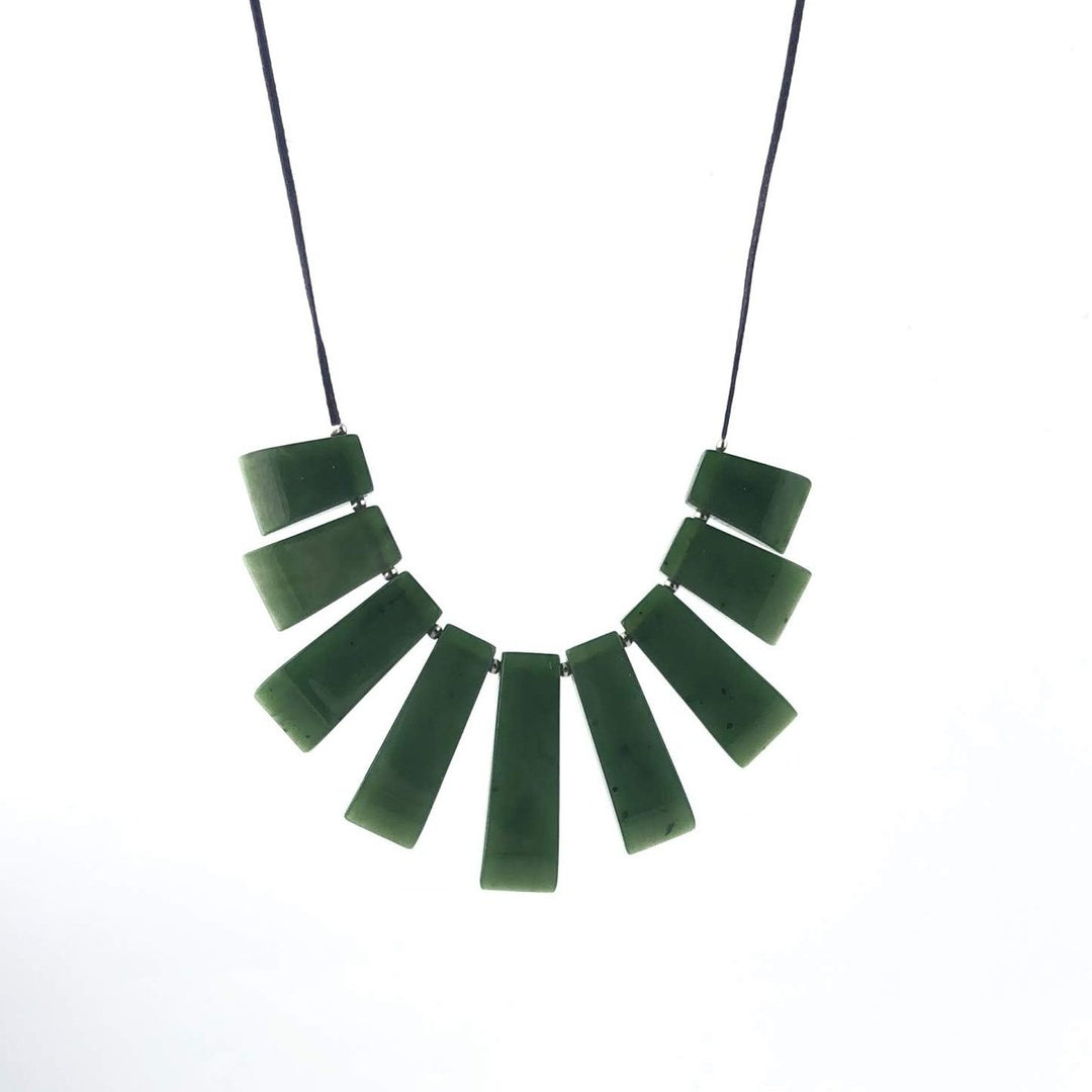 Green jade necklace with multiple rectangular bars arranged in a curved fan on a dark cord.