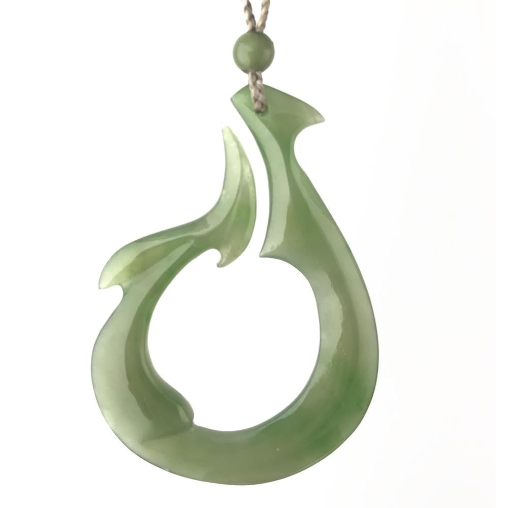 Polar Jade Pendant in pale green with a curved teardrop form and open circular cutout on a cord