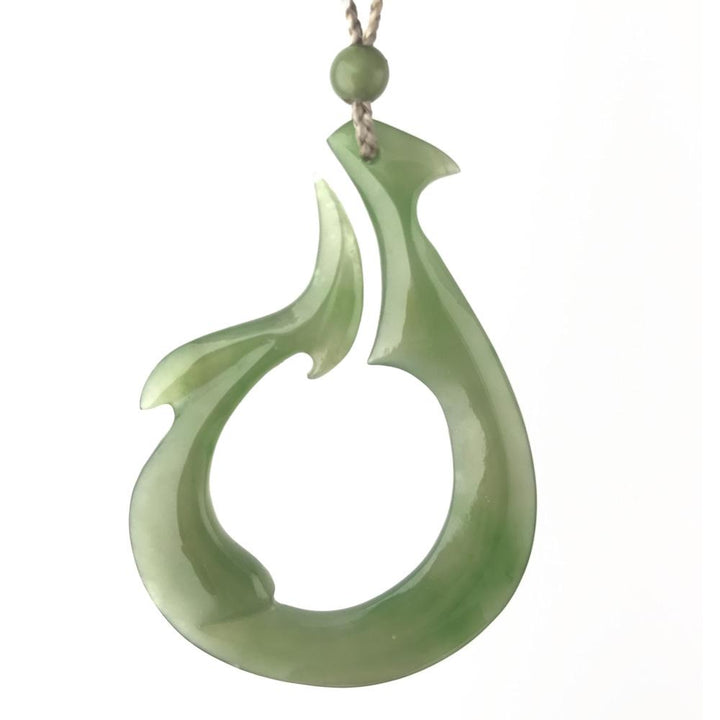 Polar Jade Pendant in pale green with a curved teardrop form and open circular cutout on a cord