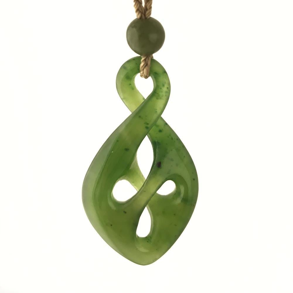 Green circular bead above a jade green twist pendant on a brown cord