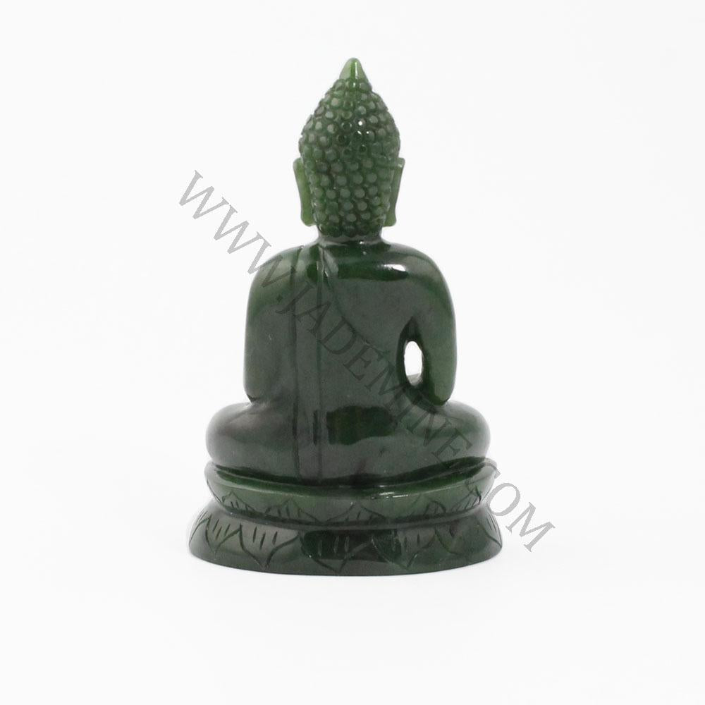 Thai green jade Buddha statue seen from behind in meditation pose on a carved base