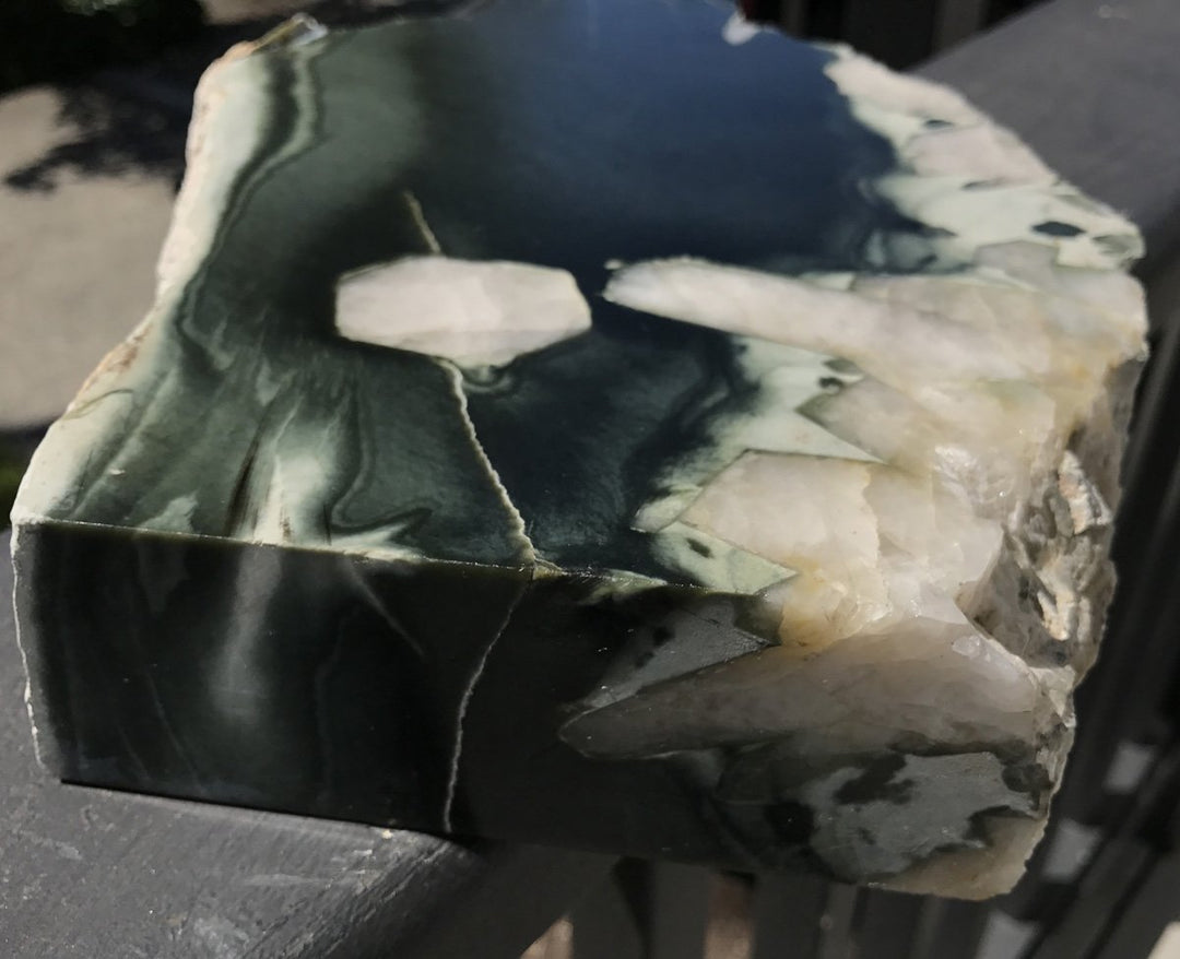 Dark green Olive Wyoming sample cut to reveal quartz crystal inclusions