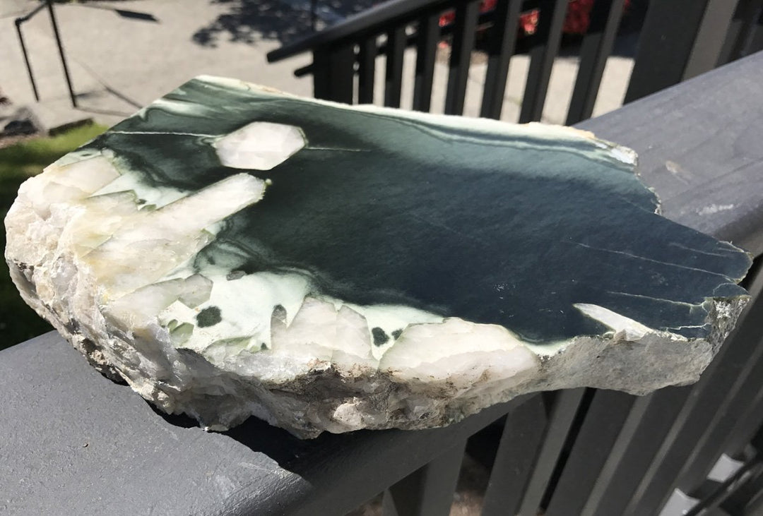 Olive Wyoming specimen with deep green face and white quartz crystals along the perimeter