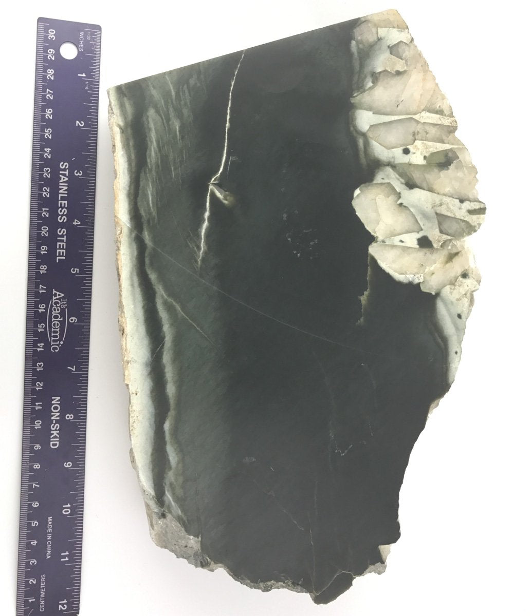 Olive Wyoming slab with dark green surface and quartz crystal cluster along the right edge shown with a ruler for scale.