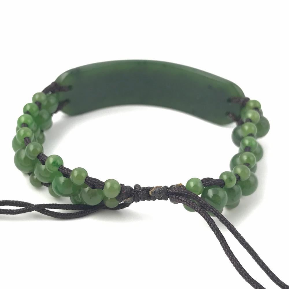 Bracelet 1833-12 green beaded bracelet with a curved central piece on dark cord