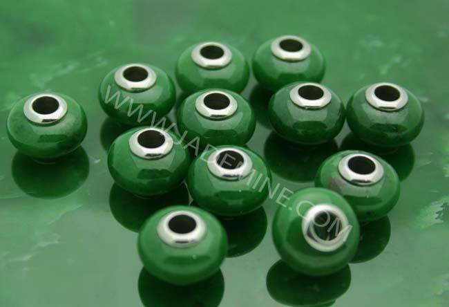 Cluster of green jade beads with metal cores on a glossy green surface