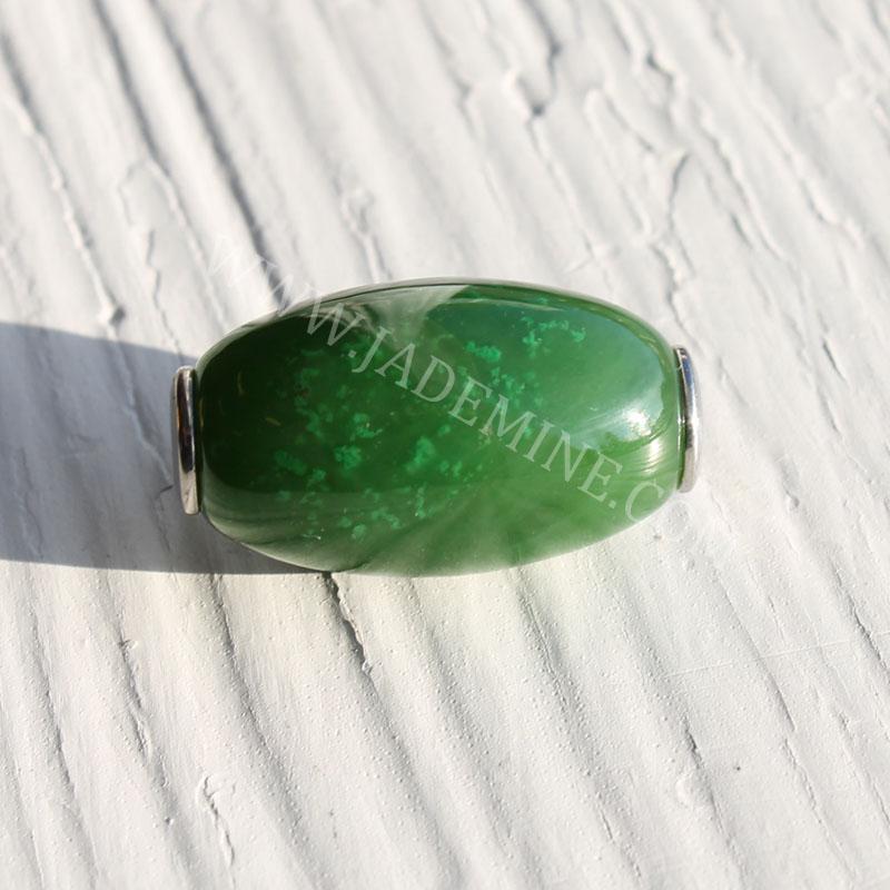 Oval green jade bead with a polished surface and silver end caps on a light textured background.