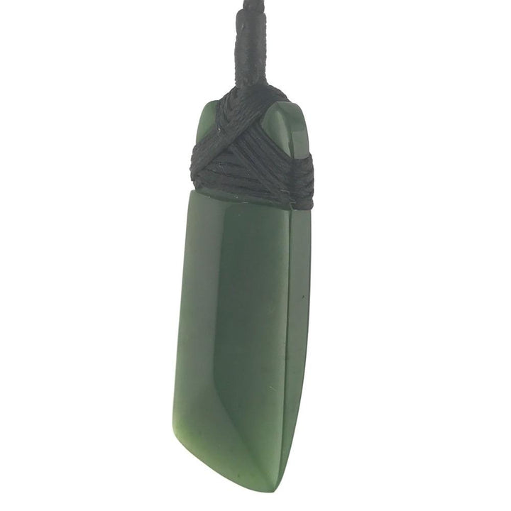 Green rectangular jade pendant bound with black cord and a loop at the top.