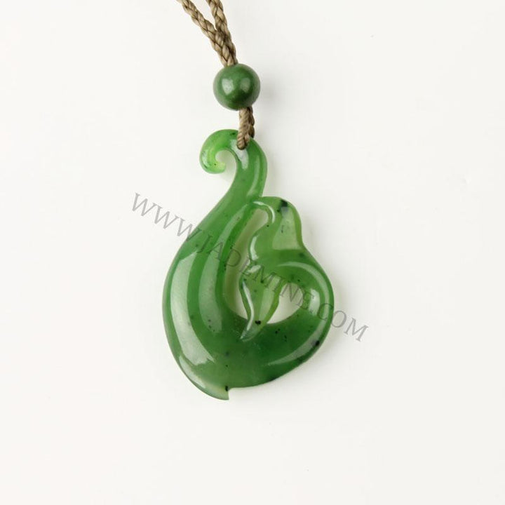 Green jade pendant carved into a curved leaflike teardrop on a beige braided cord with a round bead.
