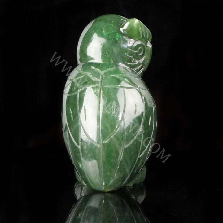 Back view of green jade owl showing carved wing lines and rounded body