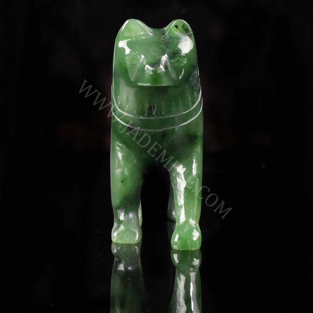 Front view of green jade husky statue standing on a black surface.