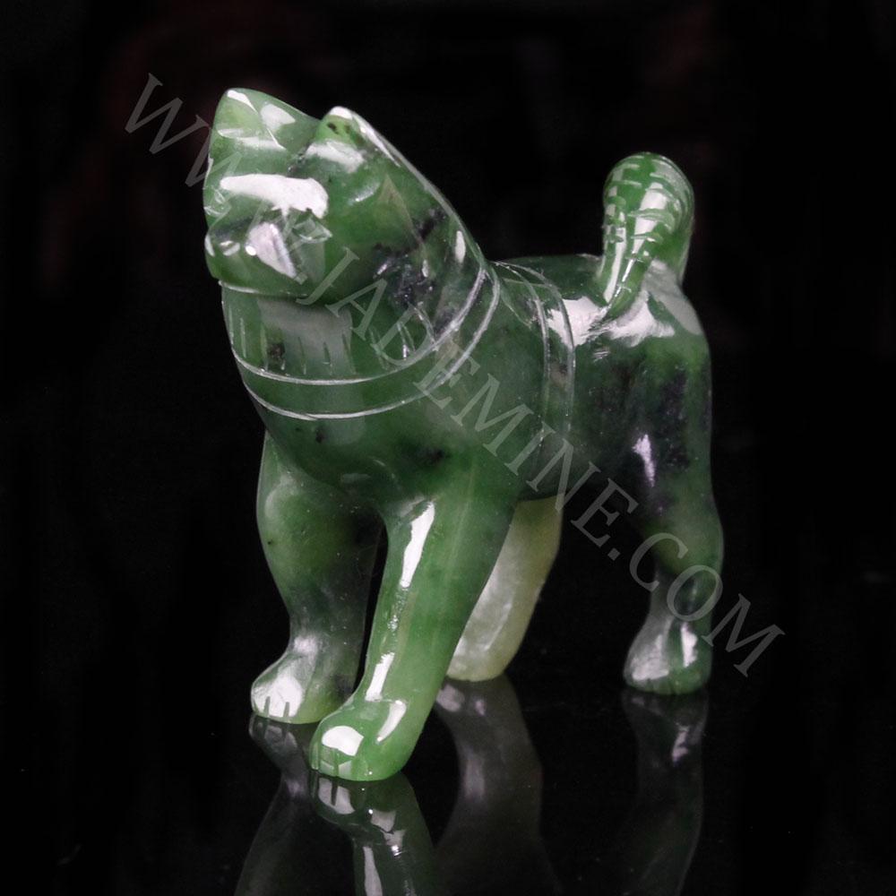 Green jade husky figurine with a raised head on a black background.