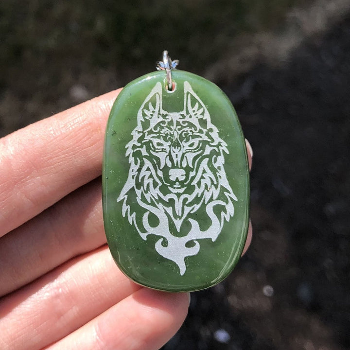 Green jade keychain with a silver wolf engraving