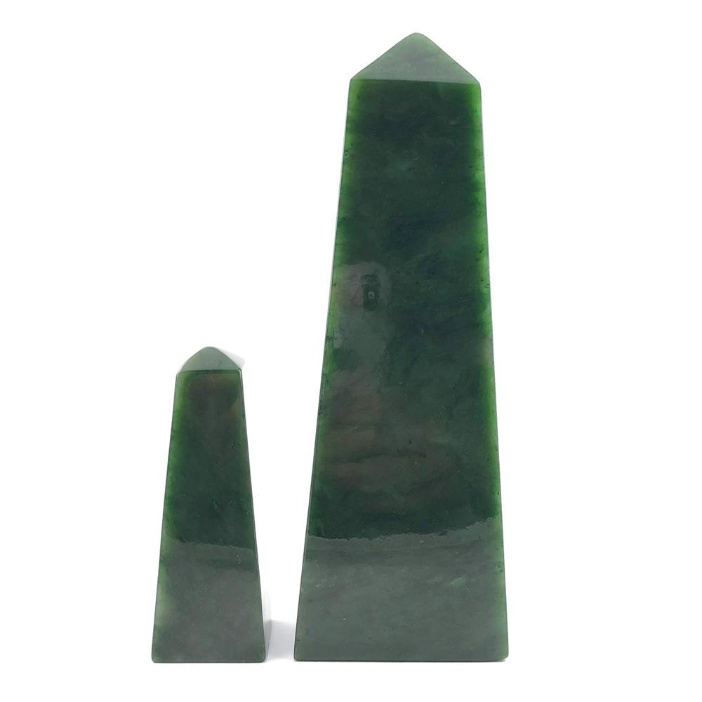 Two green Canadian jade obelisks in varying heights on a white background