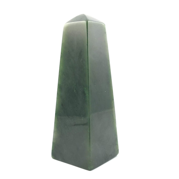 Dark green jade obelisk with a central seam on a white studio background.