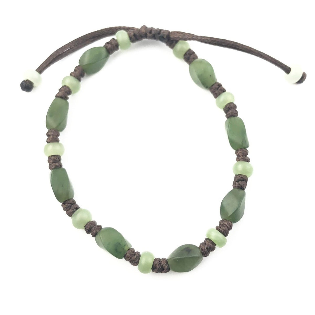 Bracelet with green stone chips and pale green beads on a dark braided cord.