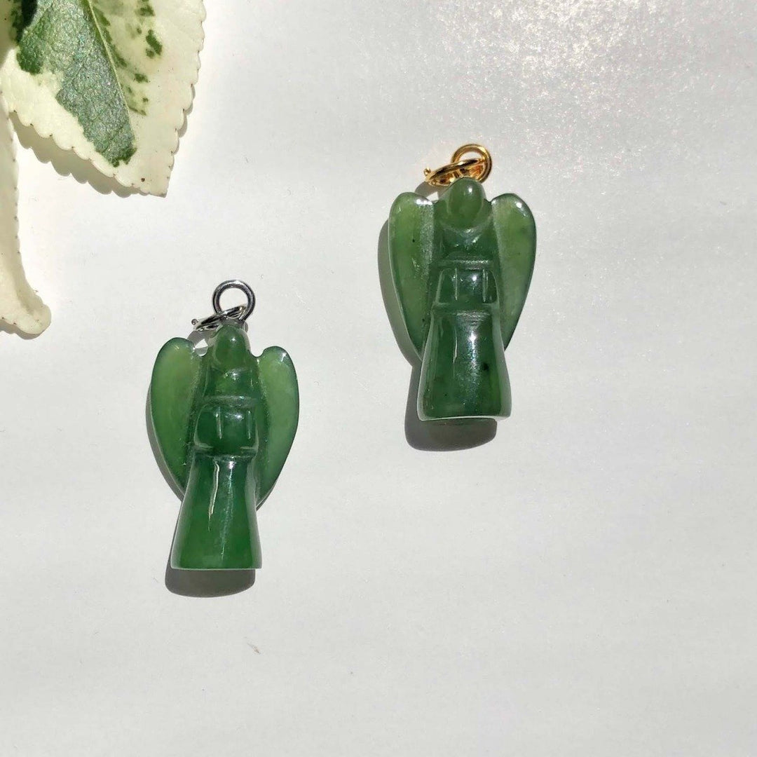 Two green jade angel charms on a white background, one with a gold loop