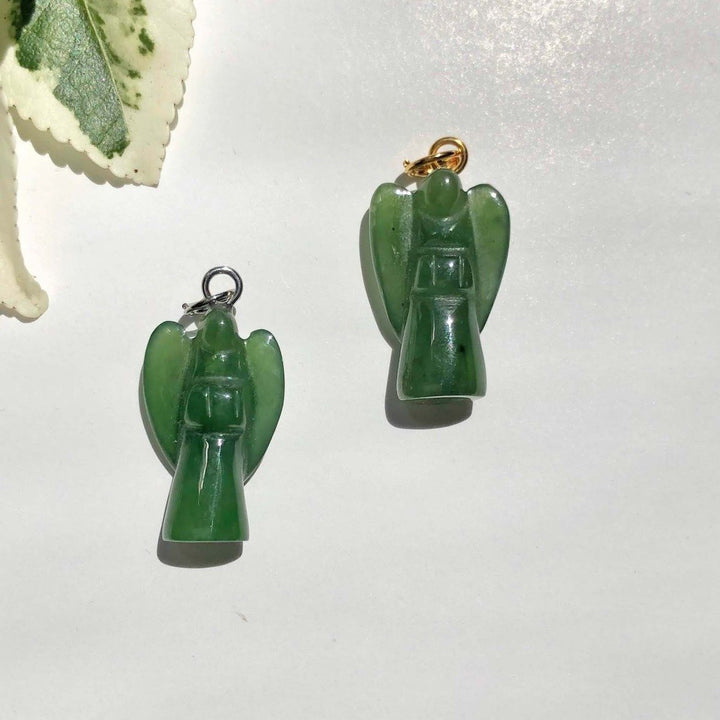 Two green jade angel charms on a white background, one with a gold loop