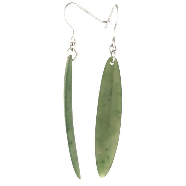 Close-up of long green jade leaf earrings dangling from silver hooks