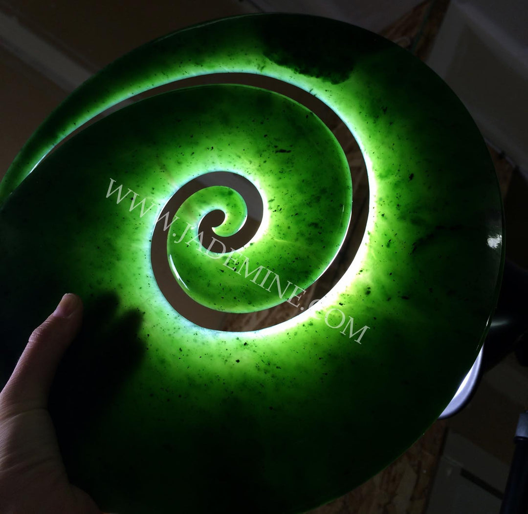 Bright green spiral sculpture with a glowing inner ring and speckled surface