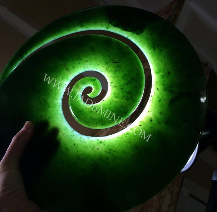 Bright green spiral sculpture with a glowing inner ring and speckled surface