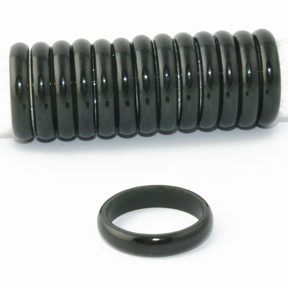 Row of glossy black jade narrow band rings aligned along a rod with one ring lying in front